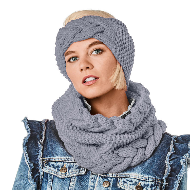 Frau trägt einen grauen Loop und ein Stirnband mit Zopfdetail, steht vor einer Jeansjacke.