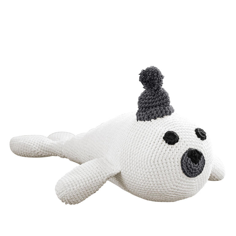 Gehäkelte weiße Robbe mit grauem Hut auf einem weichen Untergrund.