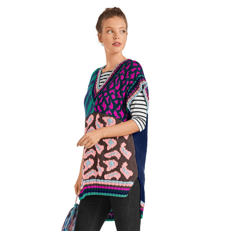 Frau trägt bunten Pullunder mit geometrischem Muster.
