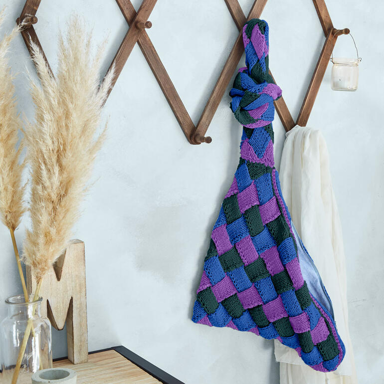 Bunte Entrelac-Tasche aus Cotonara hängt an der Wand.