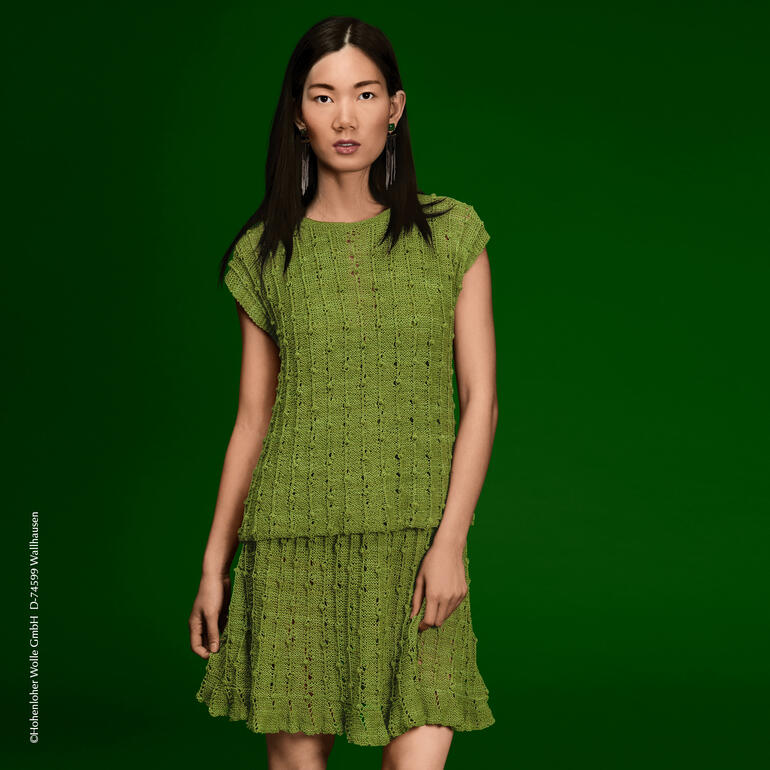 Dame in grünem Top und Rock aus El Linio mit fröhlichem Ausdruck.