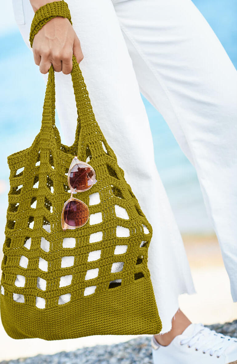 Olivenfarbene Tasche aus Essentials Organic Cotton, mit Sonnenbrille abgebildet.