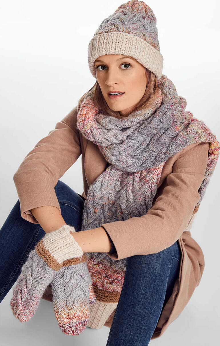 Frau trägt Mütze, Handschuhe und Schal aus Monello-90 Color von Junghans-Wolle.