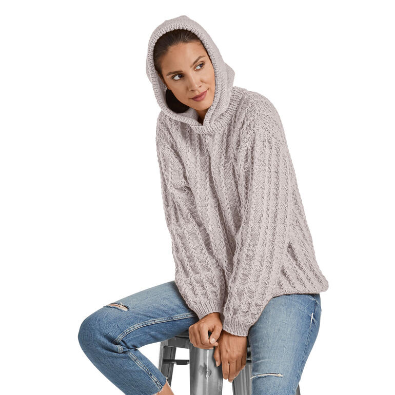 Grauer Pullover mit Kapuze, entspannt getragen von Frau auf Hocker.