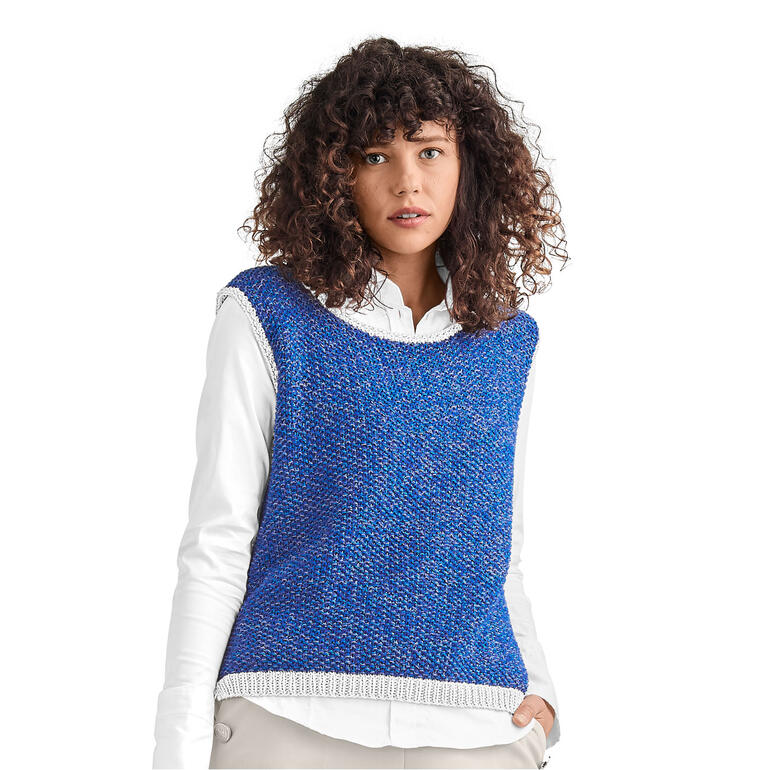 Frau in blauem Pullunder aus Oletta posiert vor neutralem Hintergrund.