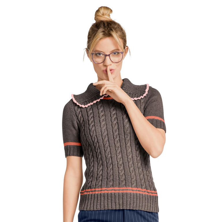 Frau in einem kurzen, gestreiften Pulli aus Seidana, lächelt geheimnisvoll.