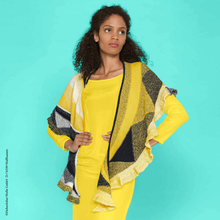 Tuch aus Zauberperlen in gelb und schwarz, drapiert über ein gelbes Kleid.