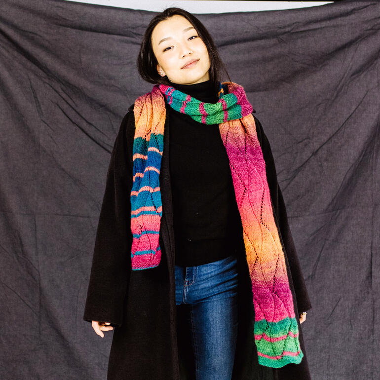 Frau trägt einen bunten Schal mit verschiedenen Farben.