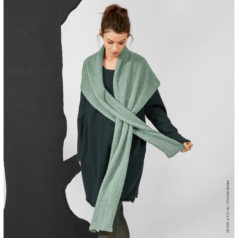 Frau trägt grünes Dreiecktuch aus Suri Alpaca von LANG Yarns über schwarzem Outfit.