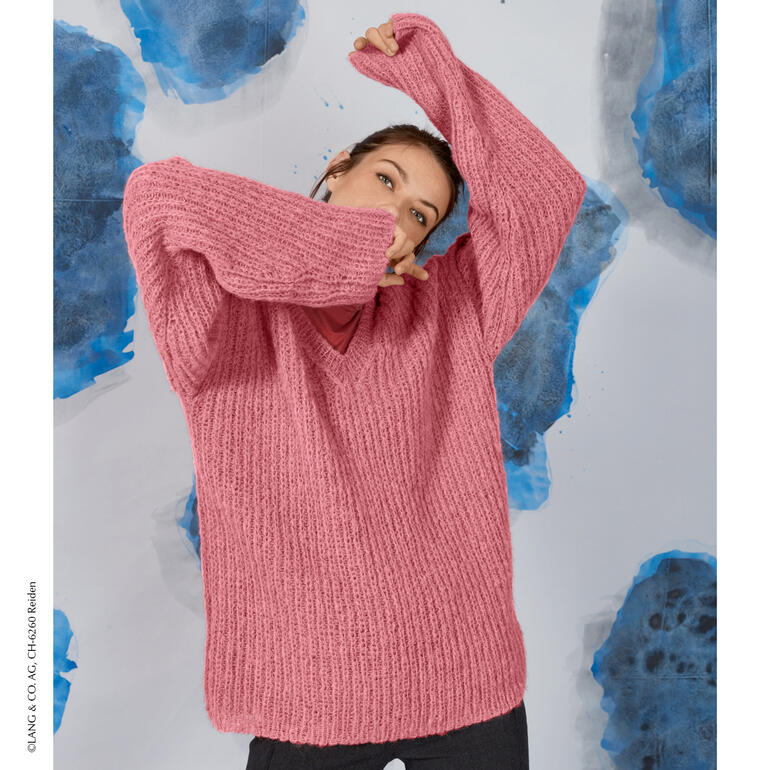 Frau in rosa Pullover aus Suri Alpaca von LANG Yarns in lässiger Pose.