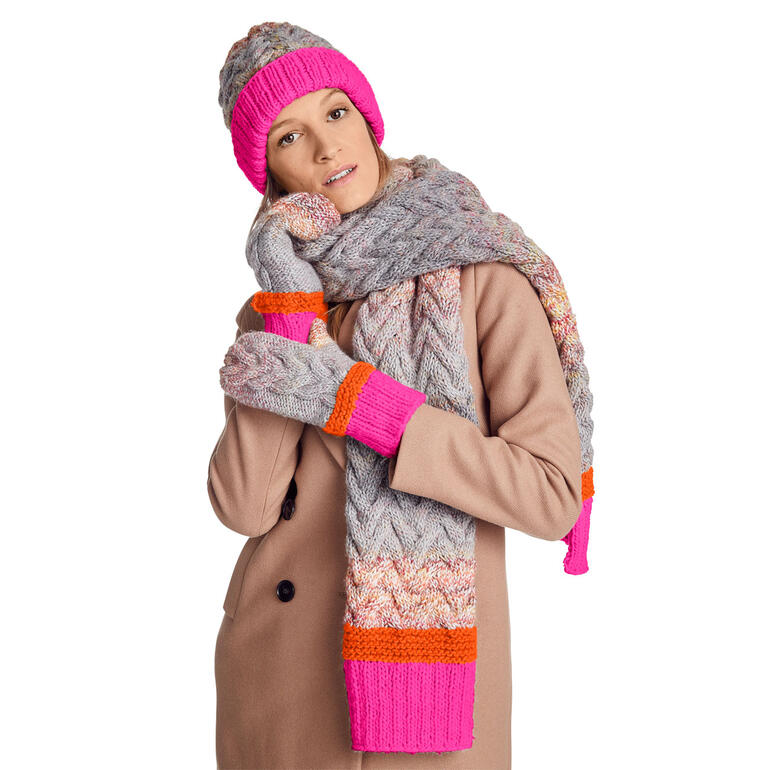 Set aus Mütze, Handschuhen und Schal in bunten Farben, getragen von einer Frau.