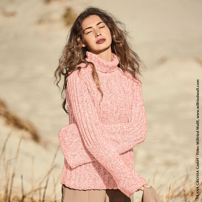 Rosa Pullover aus Cool Merino, getragen von einer Frau in der Natur.