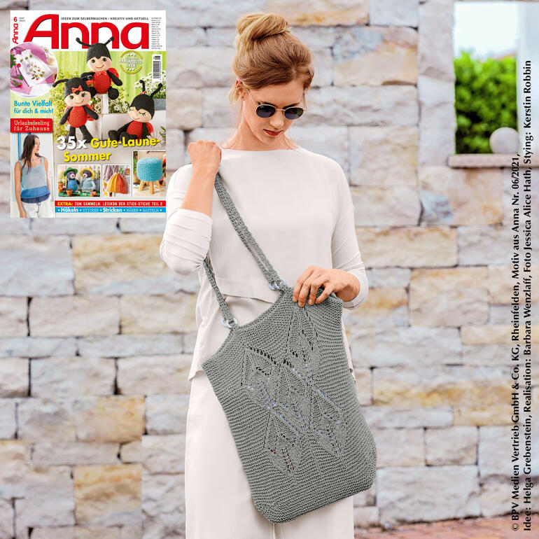 Frau trägt eine graue Häkel-Tasche aus Bandana, schaut in die Kamera.