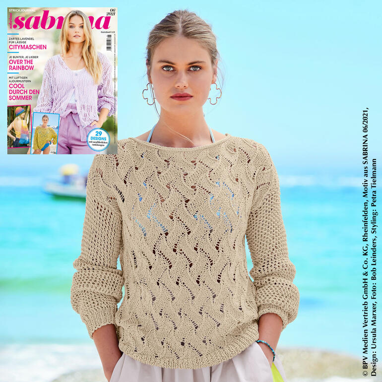 Frau trägt einen hellbeigen Pulli aus Cottonprima am Strand.