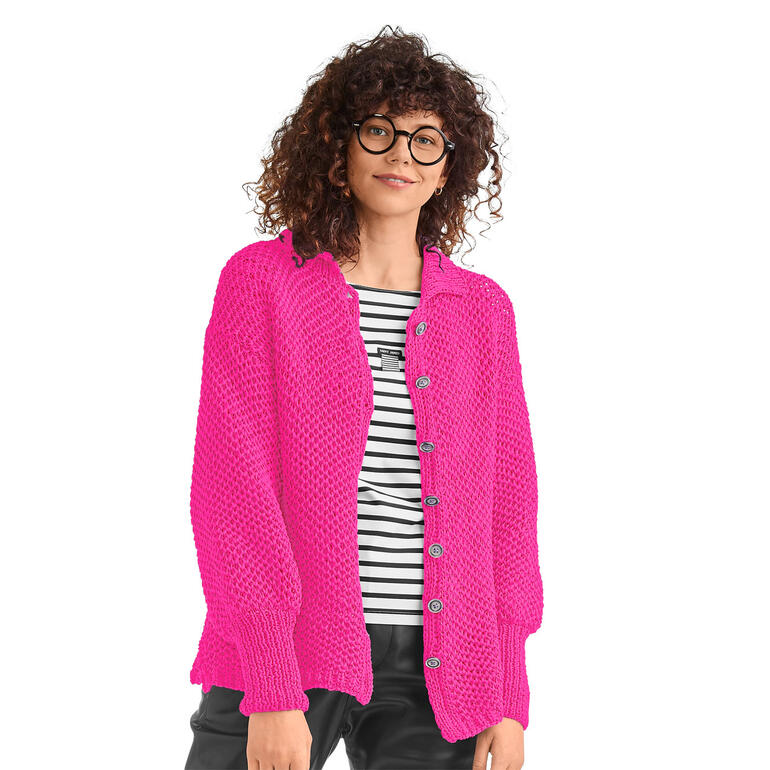 Frau in einer hellrosa Jacke aus Bandana, lächelnd mit runder Brille.