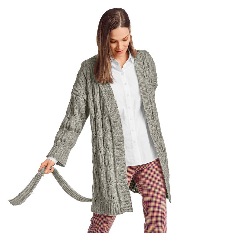 Frau in einer grauen Jacke aus Wool-Cotton mit Zopfdesign, die sich leicht dreht.