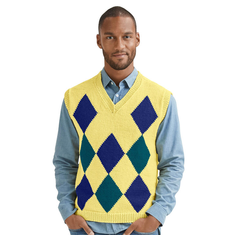 Mann posiert in einem gelben Herrenpullunder mit Graffiti-Motiv auf blauer Hemd.