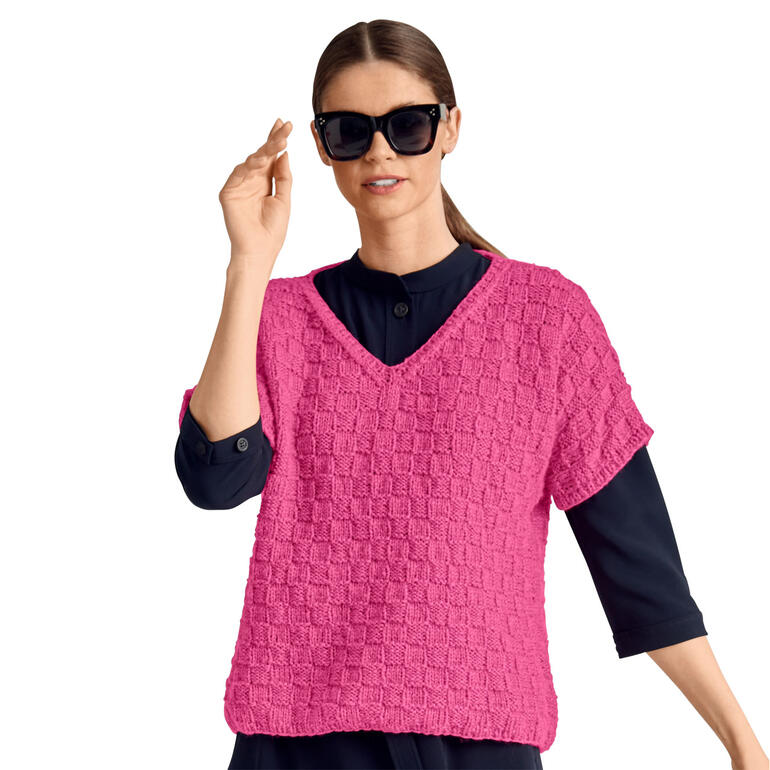 Frau in pinkem Pullover mit karierter Struktur, spielt mit Handbewegung.