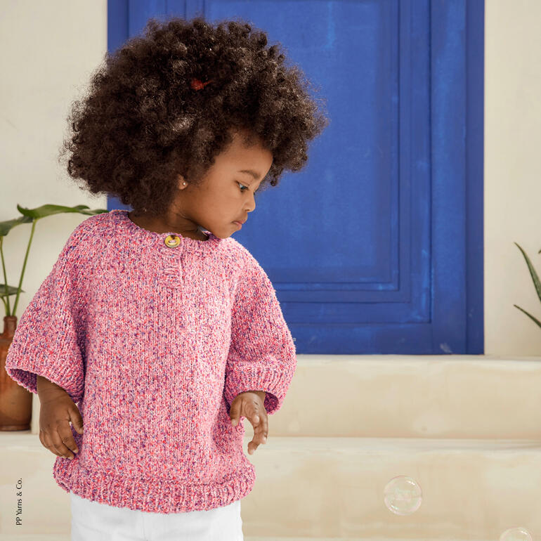 Kleines Kind in pinkem Pullover schaut nach unten, trägt einen leicht neugierigen Blick.