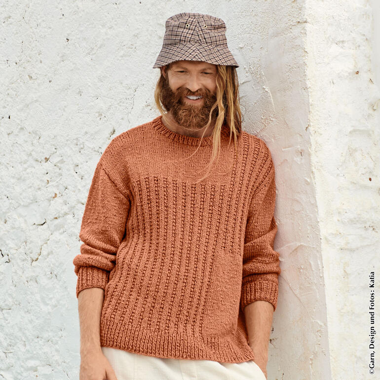 Oranger Herrenpullover mit strukturiertem Muster, entspannt lächelnd.