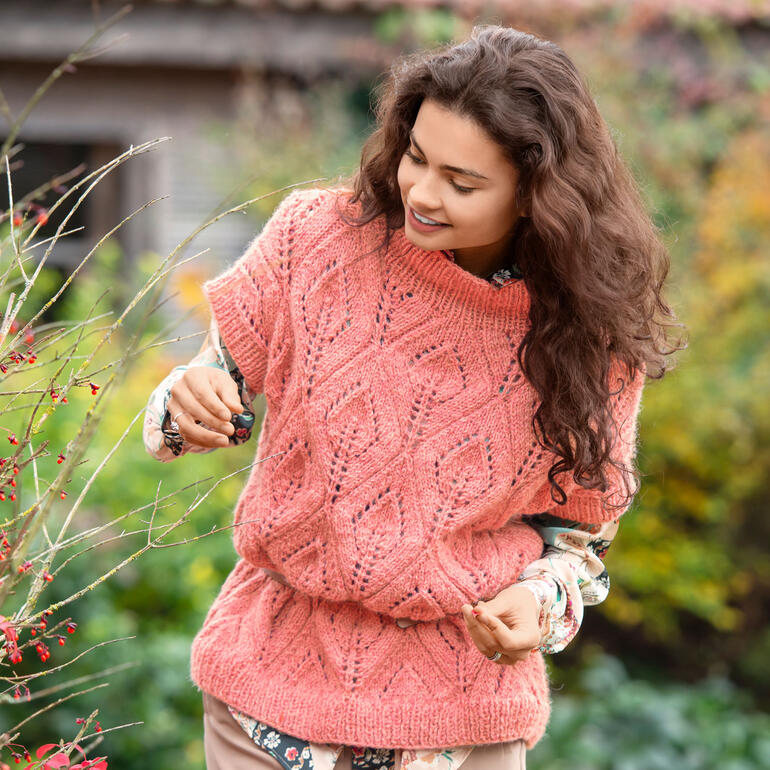 Rosa Pullover aus Alpelino mit strukturierter Oberfläche, Model lächelt.