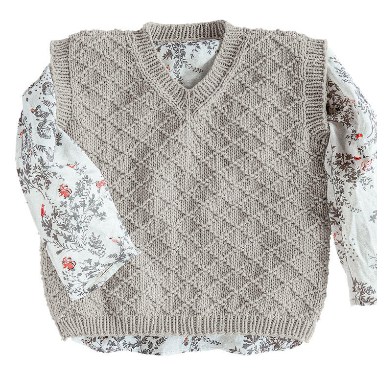 Kinderpullunder aus Recycle & Cotone mit einem gemusterten Hemd darunter.