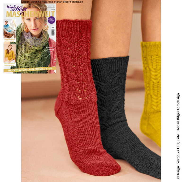 Socken aus Merino Silk Socks in Rot und Dunkelgrau, präsentiert mit einer Zeitschrift.