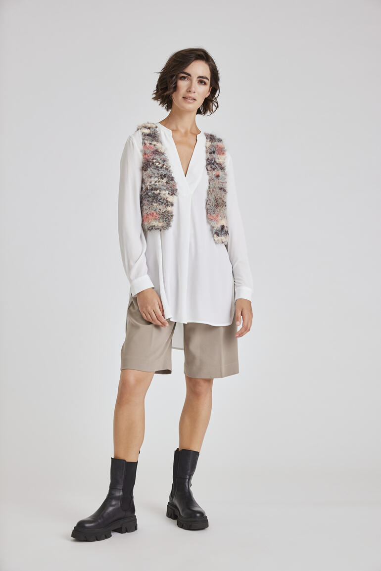 Moderne Weste aus Bo, getragen über einem schlichten Oberteil von einer Frau.