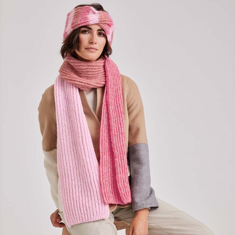 Frau trägt einen rosa Schal und Stirnband, sitzt im Freien.