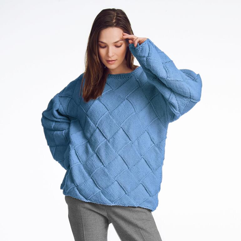 Frau in himmelblauem, strukturiertem Pullover vor heller Hintergrund