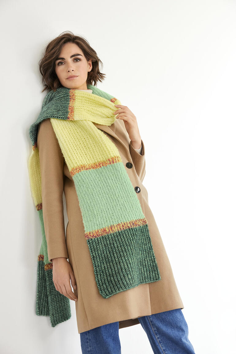 Bunter Schal aus Wool-Cotton, getragen von einer Frau im beigen Mantel.