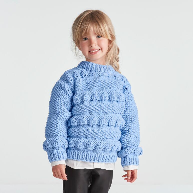 Himmelblauer Kinderpullover aus Merino Dick, getragen von einem kleinen Mädchen.