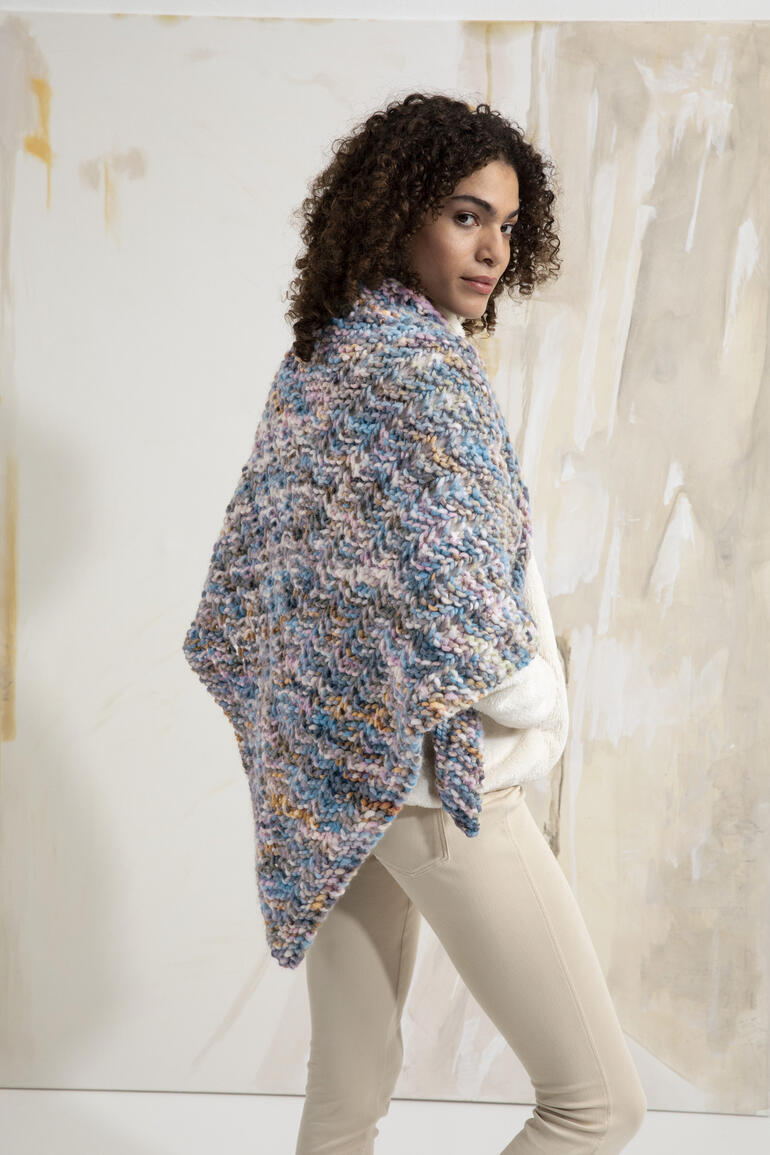 Dreiecktuch aus Bold Color, getragen über die Schultern einer Frau.