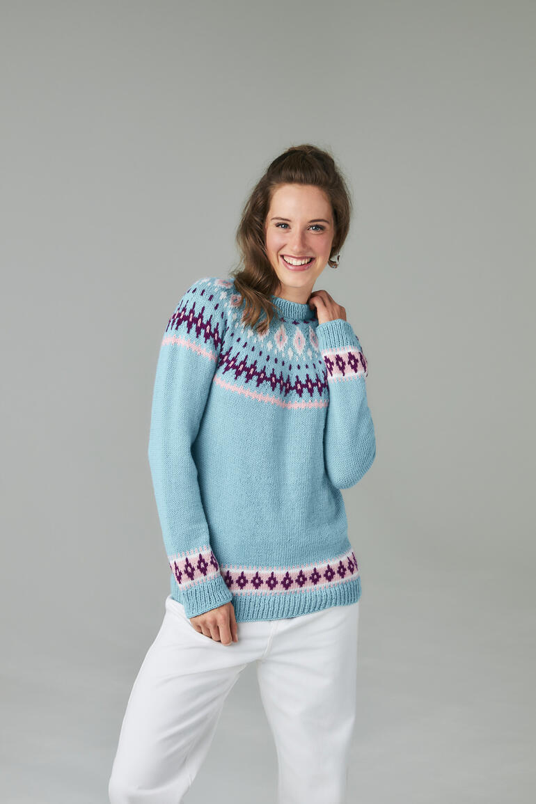 Pulli aus Charity in blauer Farbe mit geometrischem Muster, getragen von einer Frau.