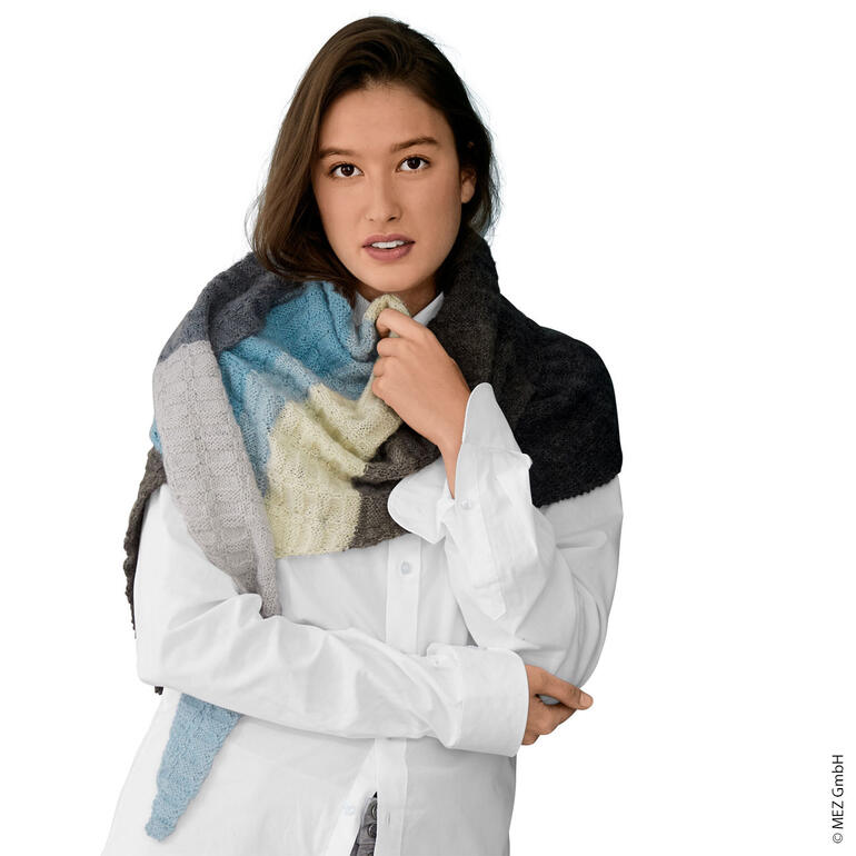 Frau trägt ein mehrfarbiges Tuch und schaut in die Kamera.