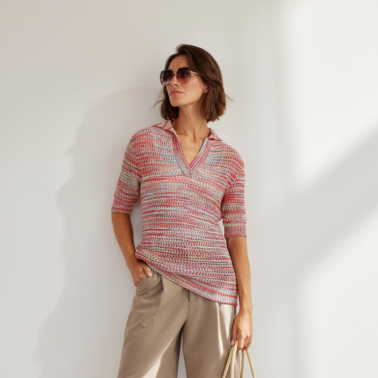 Frau in einem gemusterten Pulli aus Silka® mit Kragen, lächelt in die Kamera.