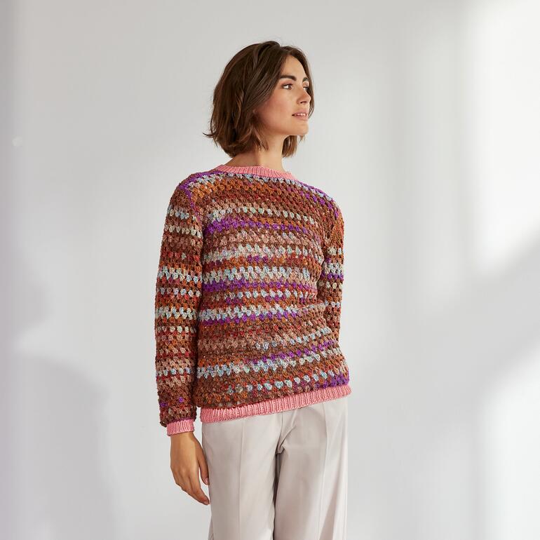 Frau in einem bunten Pullover aus Hedda und Recycle & Cotone.