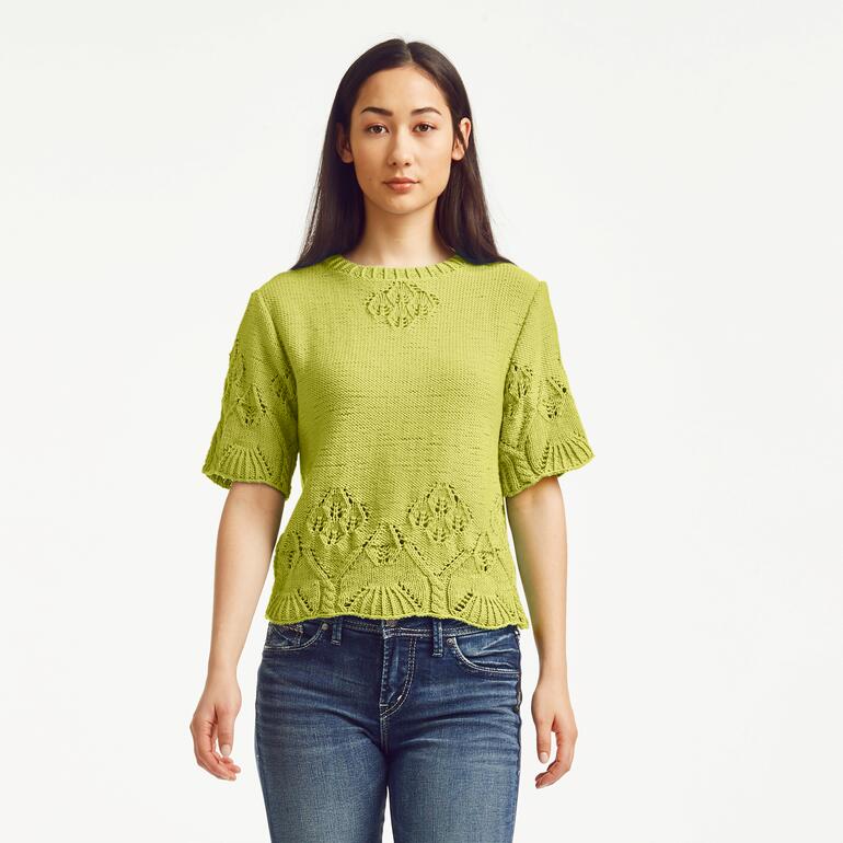Frau in einem limonengrünen Pullover aus Cotone-Emozione mit einem stylischen Design.