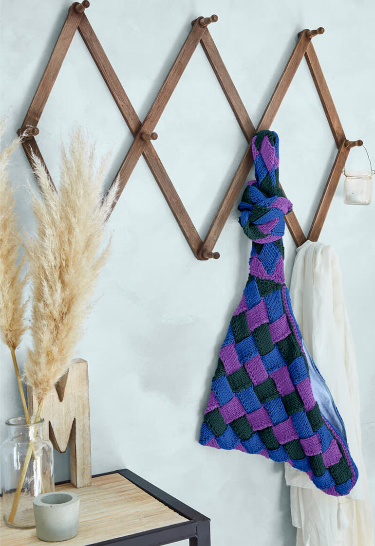 Farbenfrohe Entrelac-Tasche aus Cotonara hängt an einem Gestell