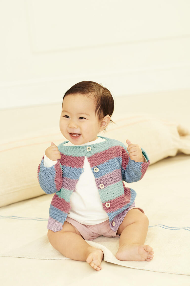 Bunte Babyjacke mit Streifen, strahlendes Lächeln des Babys.