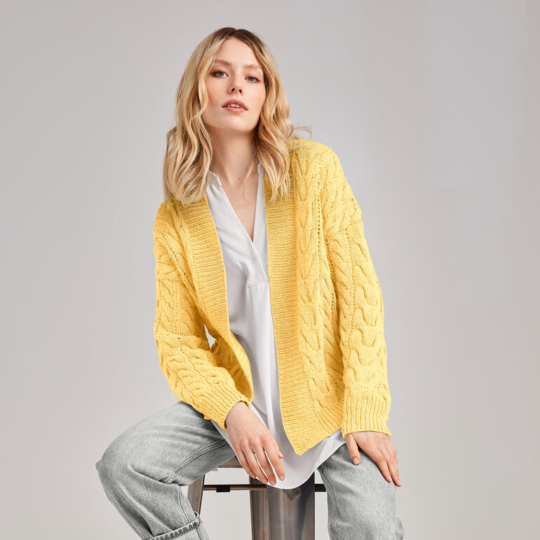 Jacke aus Inja, getragen von einer Frau in entspannter Pose mit zeitgemäßer Ästhetik.