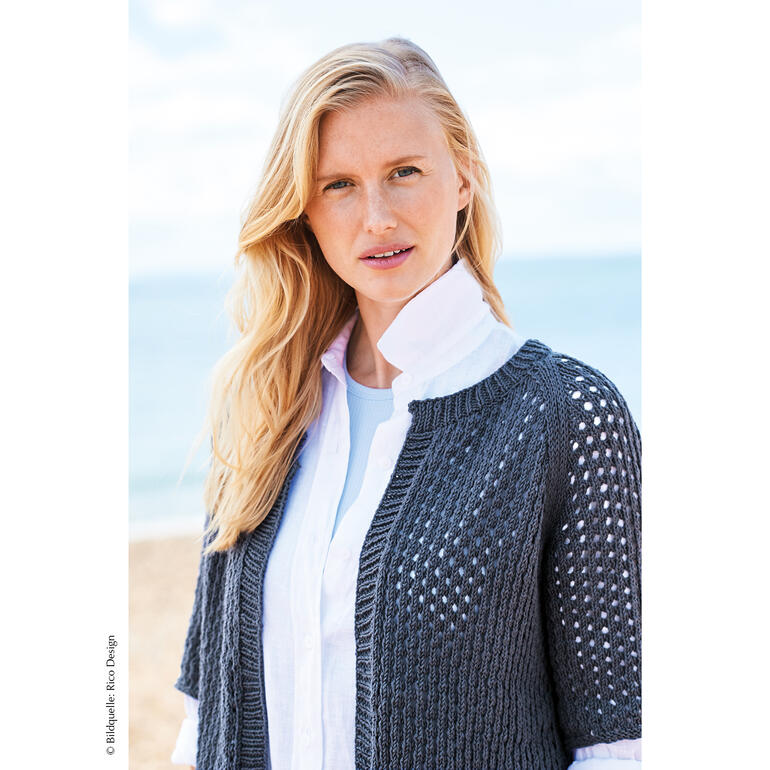 Dunkelgraue Jacke mit luftigen Mustern über einem weißen Hemd.