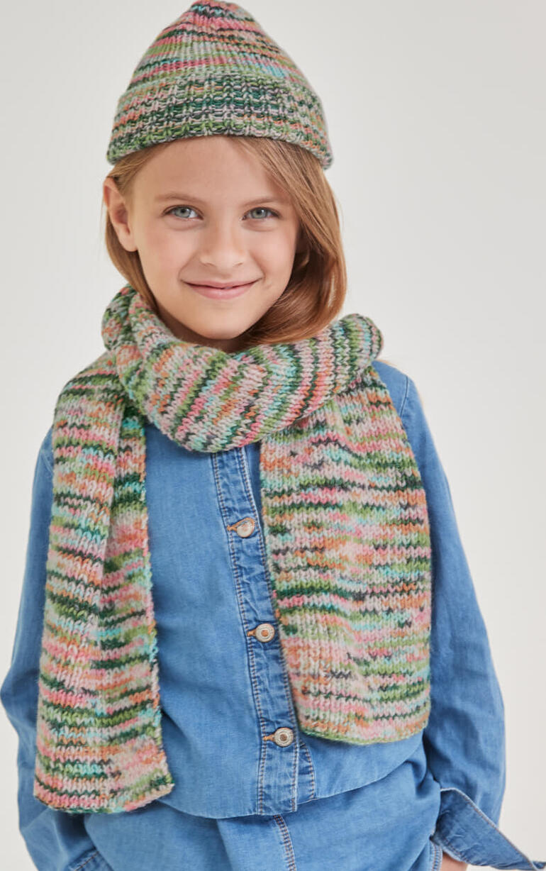 Mädchen in einem Schal und einer Mütze aus Merino-Print.