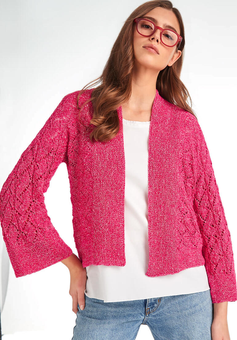 Frau trägt eine pinke Jacke aus Contrato und sitzt lässig.