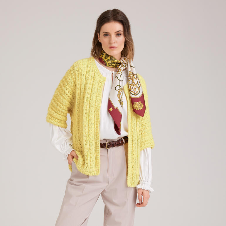 Helle, gelbe Jacke mit offenen Vorderteil, kombiniert mit buntem Halstuch.