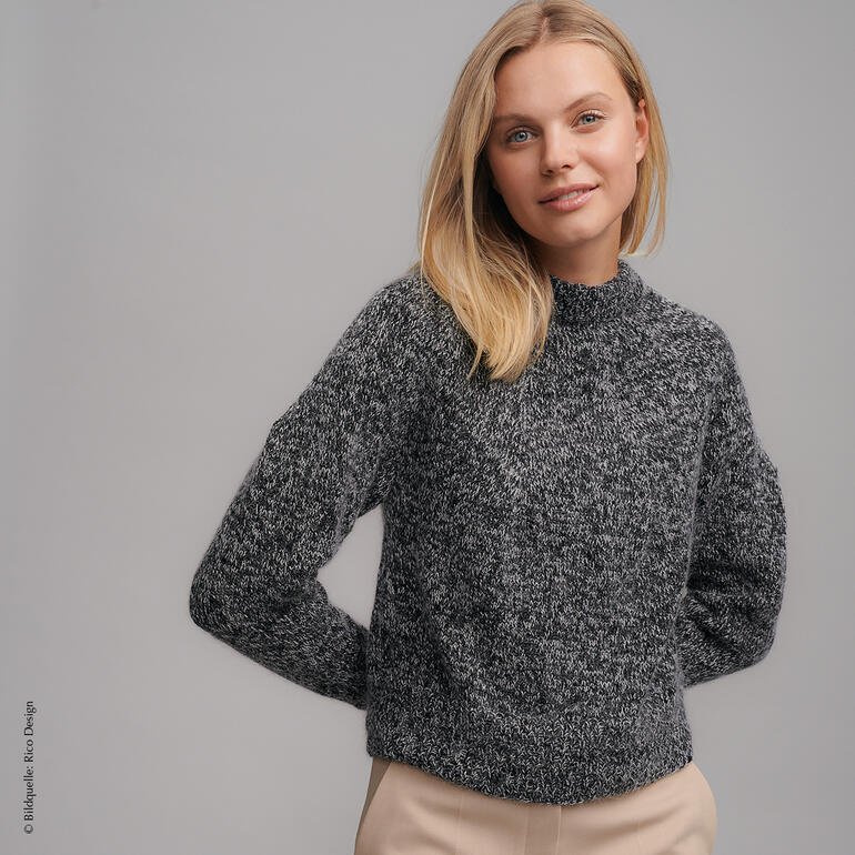 Dunkelgrauer Pullover aus Merinowolle und Kid Mohair mit stehendem Kragen, auf einem Model, in Nahaufnahme.