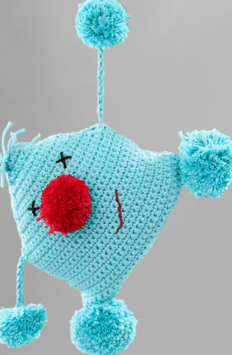 Häkel-Kuschelkerl Kalle in Himmelblau mit roter Nase und Bommel.