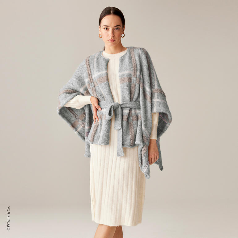 Poncho aus Phil Air Pérou in sanften Farben und gebunden um die Taille.