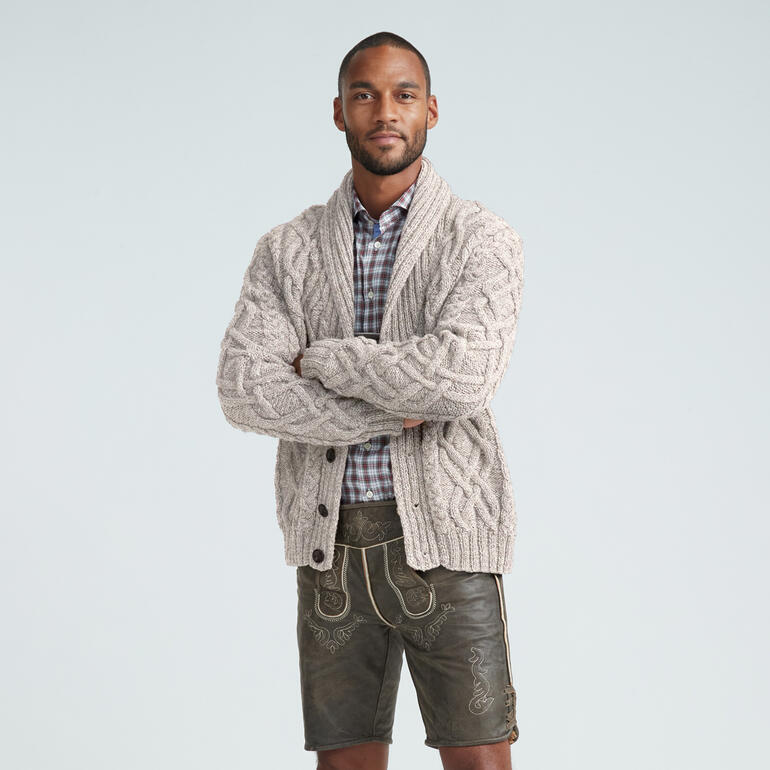 Mann trägt eine graue Herrenjacke mit Schalkragen und steht mit verschränkten Armen.