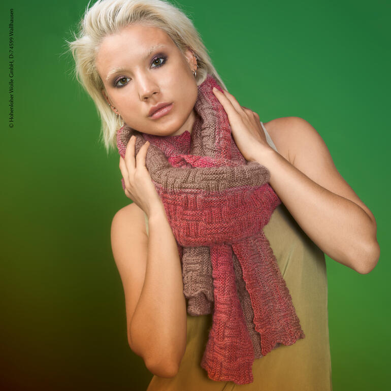 Frau trägt eine farbenfrohe Stola, Halsschmuck in Händen haltend.